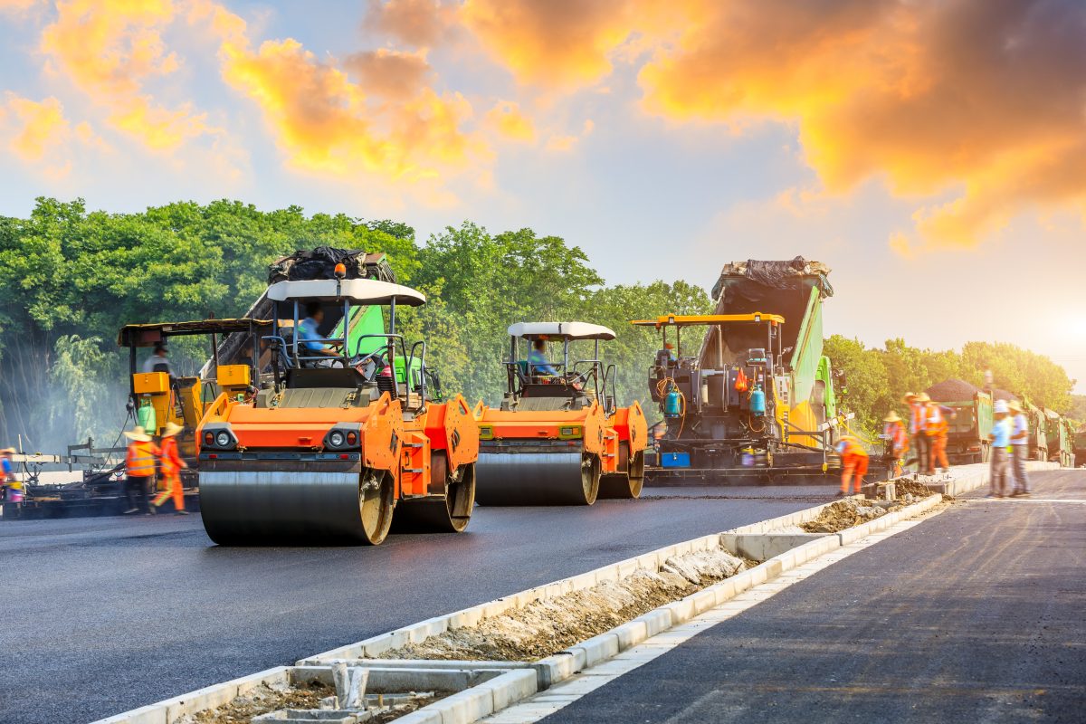 Construction Site Is Laying New Asphalt Road Pavement,road Construction Workers And Road Construction Machinery Scene.